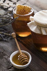 Honey and wooden stick are on a table