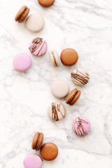 Beautiful variety of macaroons on marble background. Stylish arrangement sweet. Flat lay, top view.