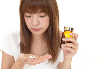 サプリメントを持つ女性