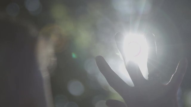 Hand in silhouette raised up to the sun blackmagic ursa mini 4,6k