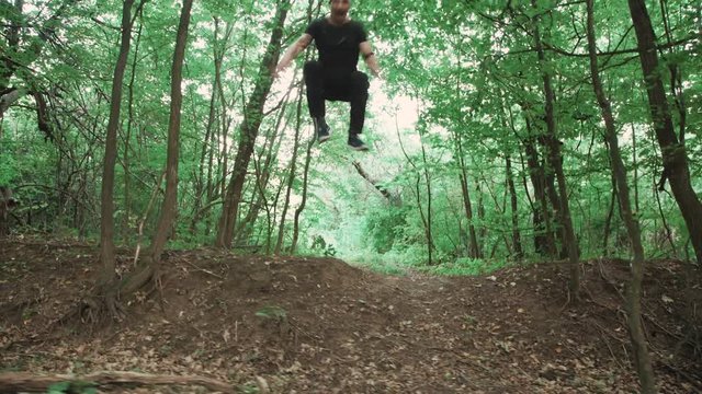 The man fastly runs away with stunts in the forest. 4K