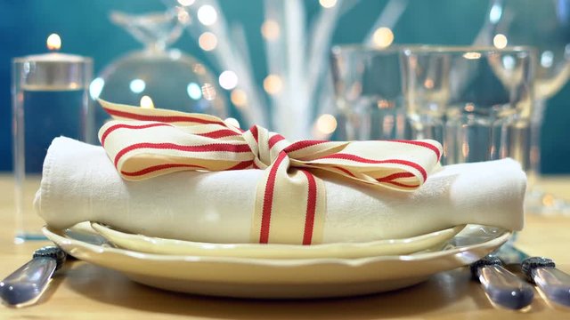 Close up of place setting with focus on napkin in elegant modern table setting for Christmas, holidays or Thanksgiving.