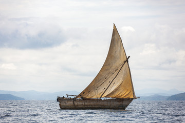 Pirogue artisanale en pleine mer avec sa voile hissée, Madagascar