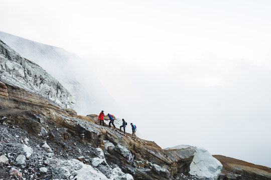 Group of young travelers walking on volcanic mountain, Kawah Ijen crater in Indonesia