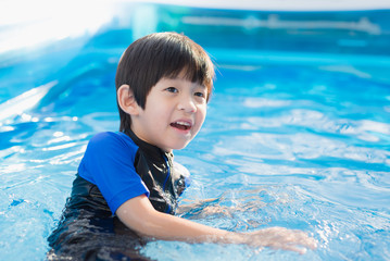 Boy swimming and playing in a pool
