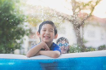 Cute Asian boy swimming and playing in a pool