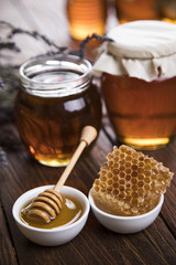Honey in jar with honey dipper on wooden background 
