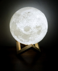 A beautiful LED moon lamp on wooden stand. 