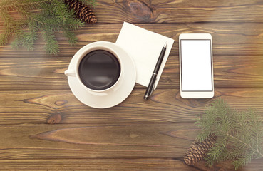 a cup of coffee, a smartphone, spruce branches. new year, christmas holidays