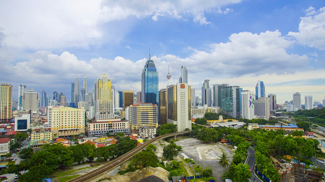 Kuala Lumpur city skyline during summer with dramatic blur sky at background.