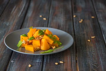 Salad with pumpkin, walnuts and green leaves