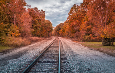 Railway track with a curve and trees in autumn colors, United States