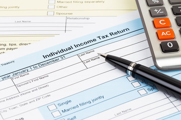 Tax form with pen and calculator; document are mock-up