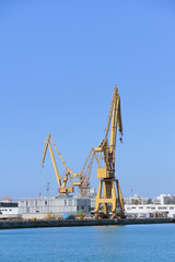 port cranes in the harbour of cadiz, spain