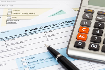 Tax form with pen and calculator; document are mock-up