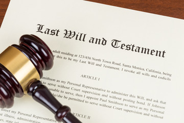 Last will and testament with wooden judge gavel; document is mock-up not real
