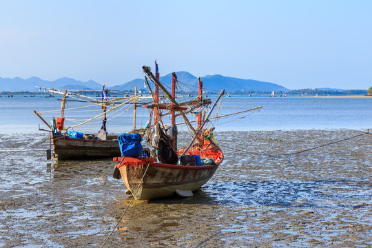 Traditional fishing boat on beach during low tide at Prachuap Khiri Khan