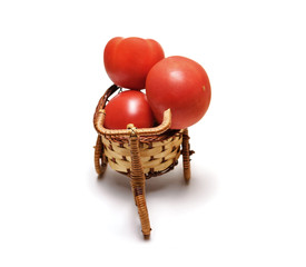 Red tomato in a basket on white