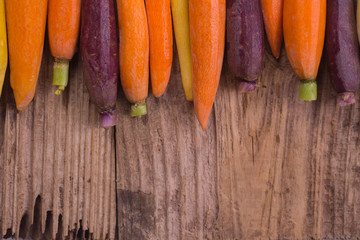 Rainbow carrots on a rustic wooden background. Healthy eating concept.Copy space. 
