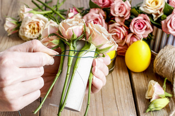Woman making floral arrangement with roses and candle, tutorial.