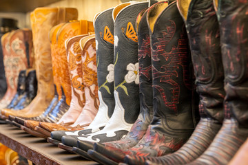 Cowboy boots on a shelf in a store aligned