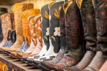 Zelfklevend Fotobehang Cowboy boots on a shelf in a store aligned © IrinaN
