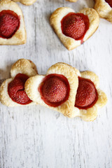 Puff pastry cookies in heart shape filled with strawberries