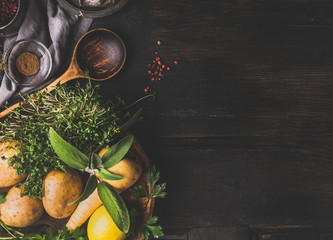 Food and cooking background with vegetables , flavor herbs and cooking spoon on dark rustic background, top view, place for text