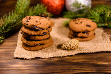 Obraz na płótnie Canvas Chocolate chip cookies and christmas decorations on a wooden table