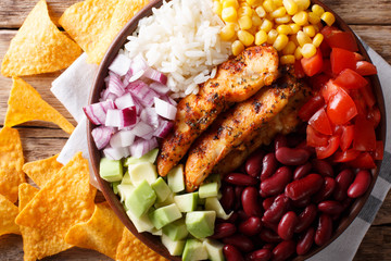 Burrito bowl with grilled chicken and vegetables close-up. Horizontal top view