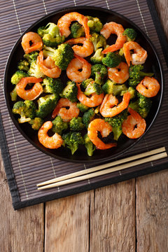 Stir frying shrimp with broccoli closeup. Vertical top view