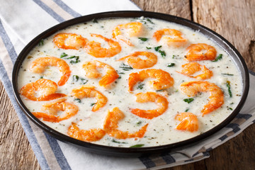 Shrimp with spinach and spices in creamy cheese sauce close-up. horizontal