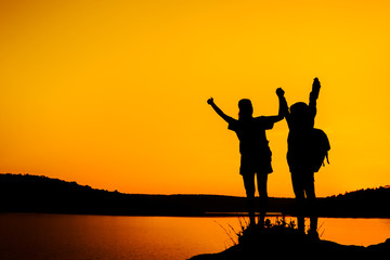 Fototapeta na wymiar Silhouette two girls join hands to celebrate the success of the trip.