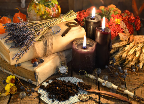 Black candles, old books, lavender flowers and magic objects on witch table