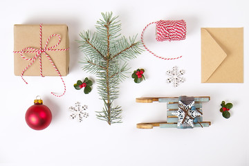 Christmas frame composition. Christmas gift,pine branch, red balls, envelope, white wood snowflakes, ribbon and red berries. Top view, flat lay, copy space