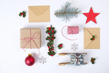 Christmas happy new year composition. Christmas gifts,pine branch,  red balls, envelope, white wood snowflakes, ribbon, red berries and present labels. Top view, flat lay, copy space.