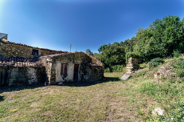Fototapeta premium Rural house in ruins typical of Galicia (Spain) in a meadow abandoned to the lake shore formed by the reservoir of Cecebre.
