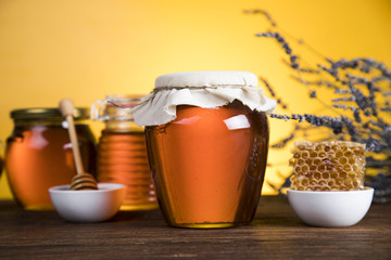Honey and wooden stick are on a table