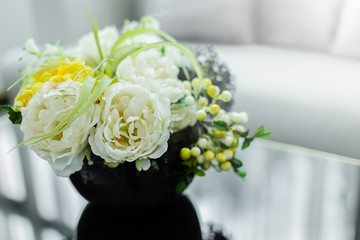 BEAUTIFUL WHITE AND YELLOW FRESH FLOWER IN SHINY GLASS VAES ON SIDE TABLE INTERIOR CONCEPT