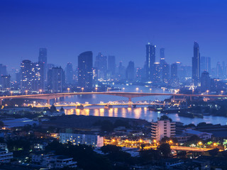 Fototapeta premium Pejzaż po stronie rzeki Bangkok. Wgląd nocy Bangkoku w dzielnicy biznesowej. at twilight.Panorama widok na panoramę Bangkoku w nocy. vintage odcień koloru