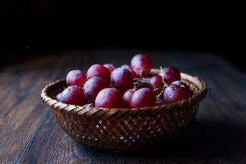 Purple Grapes in wooden basket. Dark Moody