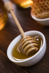 Honey and wooden stick are on a table