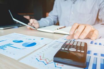 Businessman's hands with calculator at the office and Financial data analyzing counting