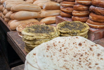 Fresh tradition iraqian bread and group of baked goods for sale at Mahane Yehuda Market, popular marketplace in Jerusalem, Israel