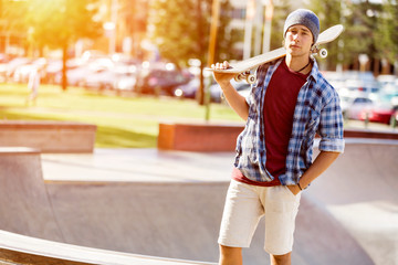 Teenage boy with skateboard standing outdoors