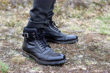 Br&auml;utigam mit schwarzen derben Boots in der Natur