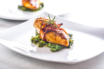 Chicken grill breast. Chicken roasted breast with bacon and spinach on white plate. Culinary food  in hotel pub or restaurant