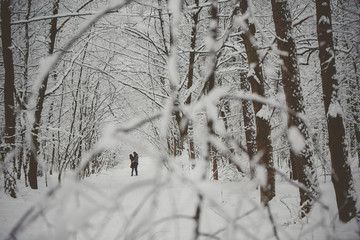 Young couple in love kissing in cold forest