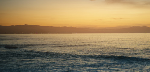 Clouds blue sky and gold sunlight sunset on horizon ocean, background seascape dramatic atmosphere rays sunrise. Relax view waves sea with ship, mockup nature evening concept, copy space for text.