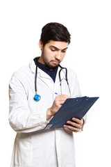 Fototapeta premium beautiful young doctor in a dressing gown with a stethoscope on a white background in the studio, records a medical history,